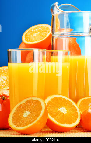 Composizione con bicchieri di succo di arancia e frutta Foto Stock