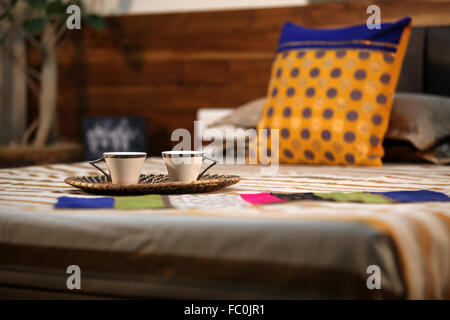 Freschi Tè serviti in un vassoio di canna sul letto la mattina. Foto Stock