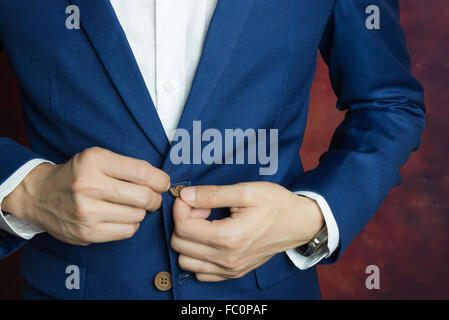 Uomo in tuta blu due i bottoni, facendo il pulsante Foto Stock