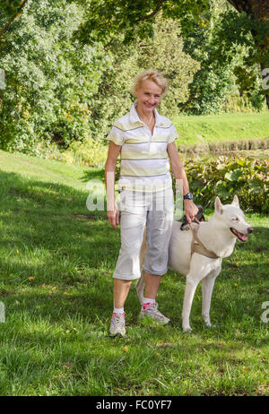 Donna con un cane in una passeggiata nel parco Foto Stock