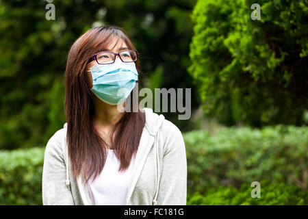 Donna indossare maschera facciale per esterno Foto Stock