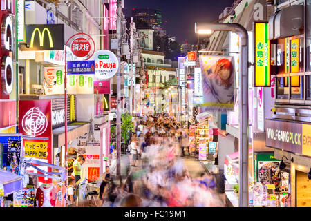 La folla a piedi attraverso Takeshita Street nel quartiere Harajuku di notte a Tokyo in Giappone. Foto Stock