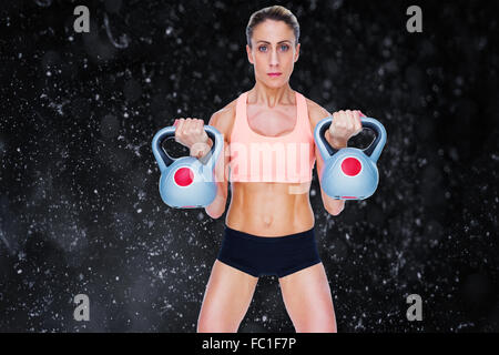 Immagine composita della grave crossfitter femmina kettlebells di sollevamento Foto Stock