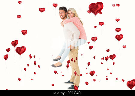 Immagine composita di uomo bello dando piggy back alla sua ragazza Foto Stock