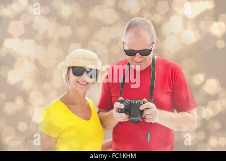 Immagine composita di felice coppia matura indossando occhiali da sole Foto Stock