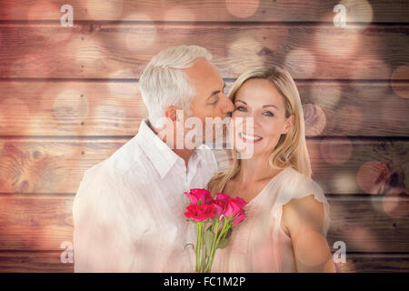 Immagine composita di affettuosa uomo baciando la moglie sulla guancia con rose Foto Stock