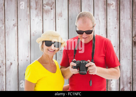 Immagine composita di felice coppia matura indossando occhiali da sole Foto Stock