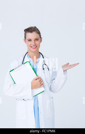 Medico negli appunti di contenimento e di presentazione con la sua mano Foto Stock