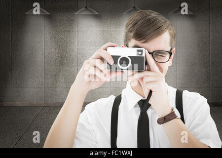 Immagine composita di geeky hipster tenendo una fotocamera retrò Foto Stock