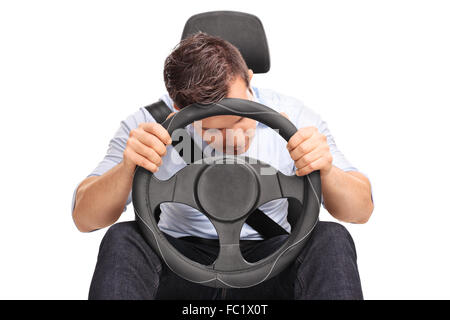 Studio shot di un giovane autista dormendo mentre la guida isolato su sfondo bianco Foto Stock