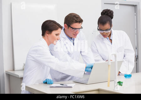 Concentrati gli scienziati che lavorano insieme con il computer portatile Foto Stock