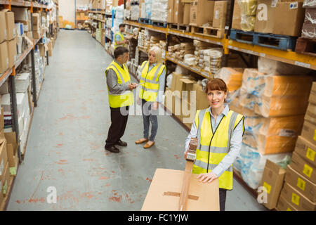 Lavoratore di magazzino la sigillatura di scatole di cartone per la spedizione Foto Stock