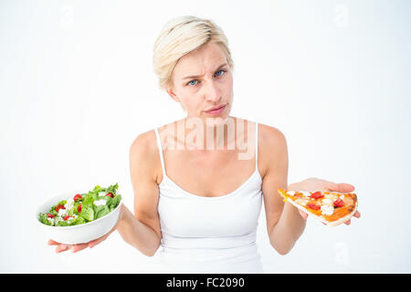 Bella donna di decidere tra la pizza e insalata mista Foto Stock