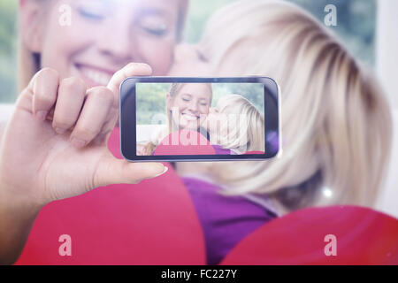 Immagine composita della mano che tiene lo smartphone che mostra Foto Stock