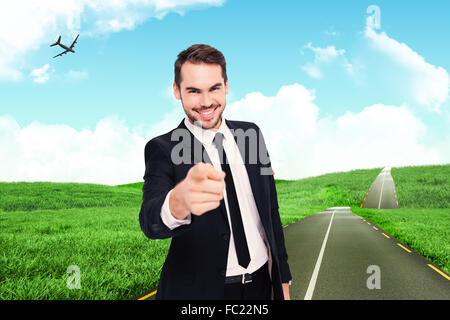 Immagine composita di happy businessman puntando alla fotocamera Foto Stock