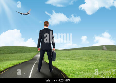 Immagine composita della vista posteriore imprenditore in piedi con la sua valigetta Foto Stock