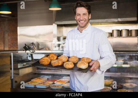 Ritratto di sorridere baker tenendo il vassoio con pane Foto Stock