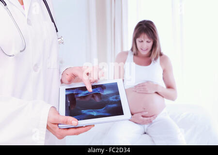 Immagine composita di dottore guardando xray su tablet Foto Stock