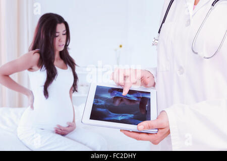 Immagine composita di dottore guardando xray su tablet Foto Stock