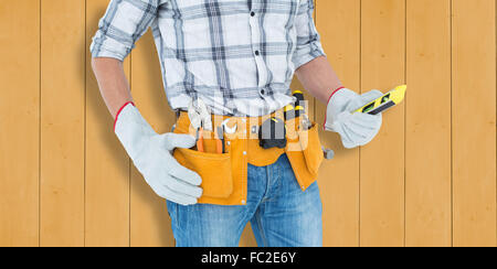 Immagine composita del tecnico mantenendo la livella su sfondo bianco Foto Stock