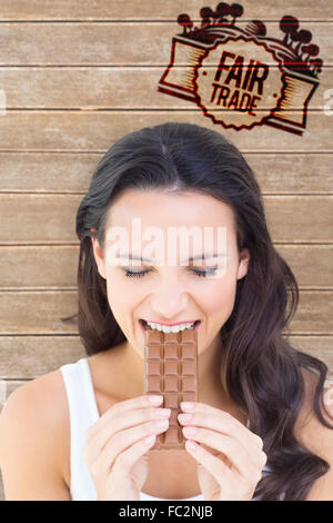 Immagine composita della bella bruna mangiare barretta di cioccolato Foto Stock