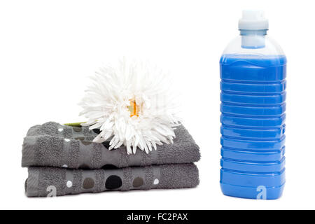 Detergente per lavanderia con asciugamani e fiore Foto Stock