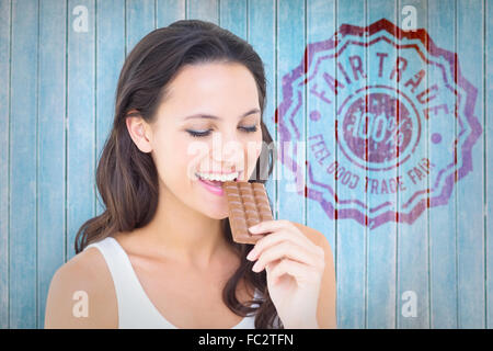 Immagine composita della bella bruna mangiare barretta di cioccolato Foto Stock