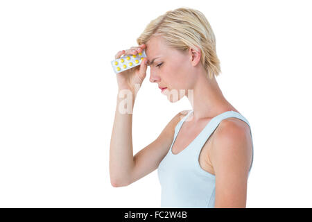 Donna attraente avere mal di testa e tenendo pack di pillole Foto Stock