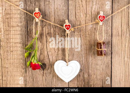 Red Rose con forma bianco Cuore e cioccolato su sfondo di legno. Il concetto di amore. Foto Stock