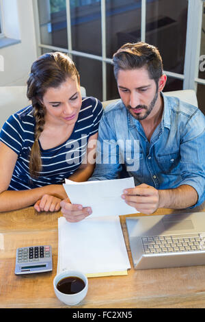 Partner di lavoro alla scrivania e la lettura di file Foto Stock