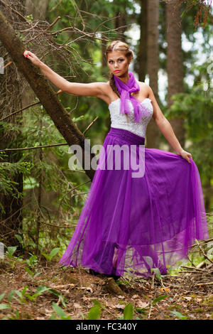 Long-capelli ragazza in abito e fascia in foresta. Foto Stock