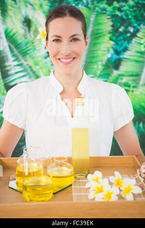 Sorridente terapista di bellezza tenendo il vassoio di trattamenti di bellezza Foto Stock