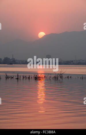 Tramonto Dorato a Ana Sagar lago in Ajmer, India con sagome di alberi e fisherman. Foto Stock