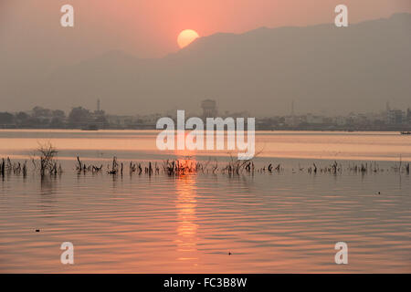 Tramonto Dorato a Ana Sagar lago in Ajmer, India con sagome di alberi e fisherman. Foto Stock