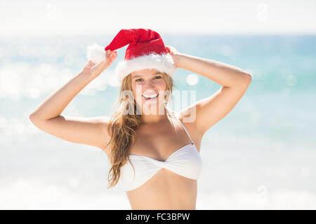 Felice bella bionda guardando la fotocamera con santa claus hat Foto Stock