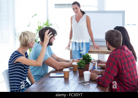 Attento collega chiedendo una domanda nel corso di una riunione Foto Stock