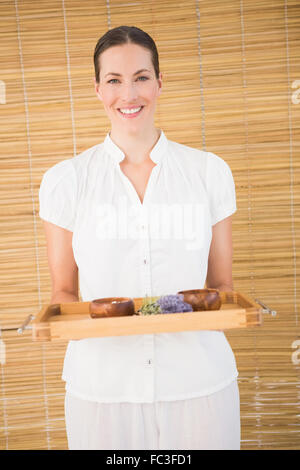 Sorridente terapista di bellezza tenendo il vassoio di trattamenti di bellezza Foto Stock