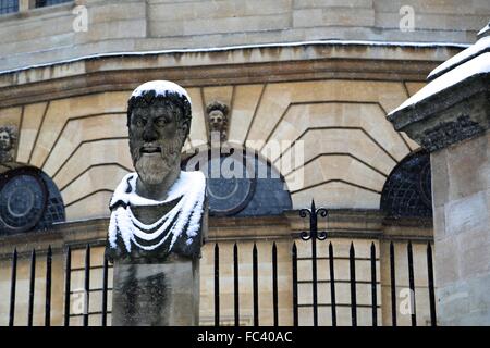 Uno degli imperatori romani dei capi al di fuori del Sheldonian Theatre in Oxford con un rivestimento leggero di neve. Foto Stock