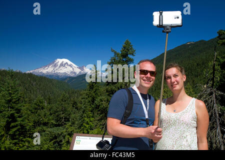 Turisti usano un selfie stick per prendere un selfie con uno smart phone a monte Rainier nello stato di Washington, USA. Foto Stock