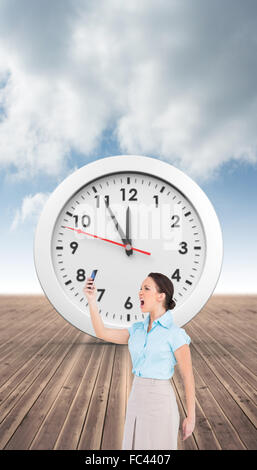 Immagine composita di angry classy imprenditrice a urlare contro il suo smartphone Foto Stock