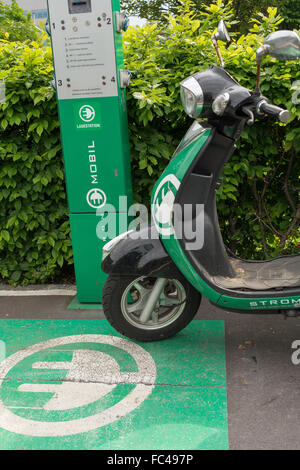 Lo scooter elettrico in corrispondenza della stazione di carico Foto Stock