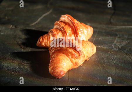 I croissant su nero ardesia tagliere Foto Stock