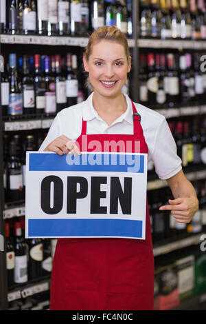 Ritratto di un sorridente donna bionda che mostra un segno Foto Stock