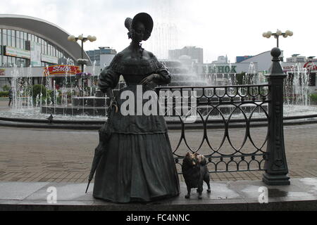 Statua di bronzo di giovane donna in stile retrò con piccolo cane rimanere sulla strada di città, settembre 2015, Minsk Foto Stock