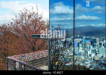 Seoul città anche in presenza di luce riflessa nelle finestre della torre di Seoul con a sinistra amore lucchetti, Seoul, Corea del Sud. Foto Stock