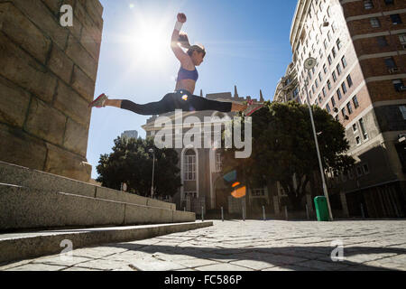 Athletic donna salta fuori le scale e fare dividere in aria Foto Stock