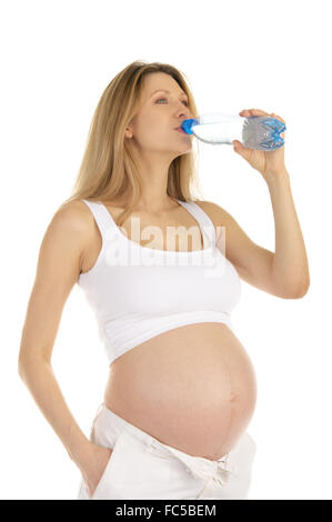 Donna incinta beve l'acqua da una bottiglia Foto Stock