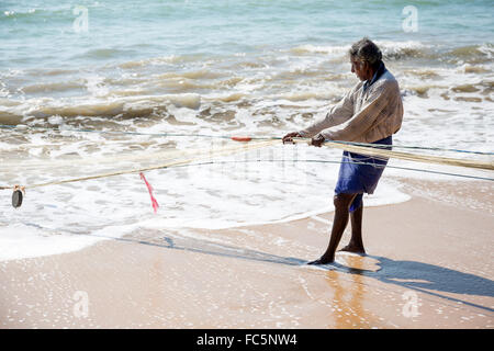 Pescatore locale tirare net dall'oceano in Tangalle, sud della provincia, Sri Lanka Foto Stock