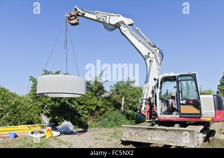 Escavatore llifting anello di calcestruzzo Foto Stock