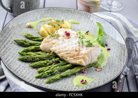 Filetto di merluzzo carbonaro con asparagi verdi Foto Stock